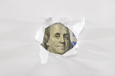 100 dolarlık banknot beyaz kağıttaki delikten görülebiliyor..
