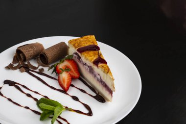 Siyah arkaplanda tabakta cheesecake