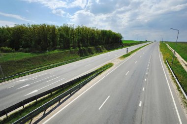 Güneşli bir günde oklarla işaretlenmiş otoban, köprüden yukarıdan görüş