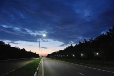 Gece gökyüzüne karşı sütunlarda yol fenerleri