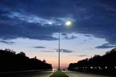Gece gökyüzüne karşı sütunlarda yol fenerleri