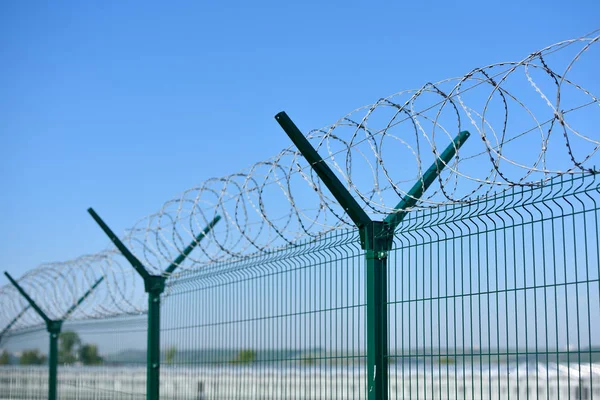 Den taggtråd stängsel på blå himmel bakgrund — Stockfoto