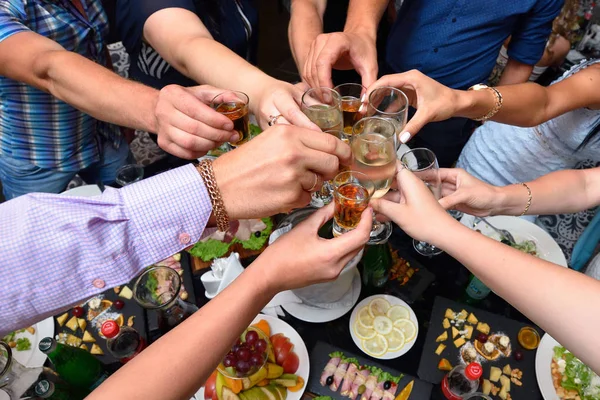As pessoas juntaram-se aos copos com uma bebida no feriado — Fotografia de Stock