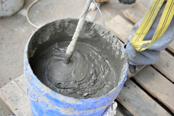 Míchání cementu se mixérem v kbelíku na ulici — Stock fotografie