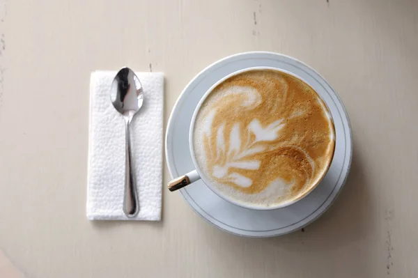 Чашка кофе и ложка на винтажном столе — стоковое фото
