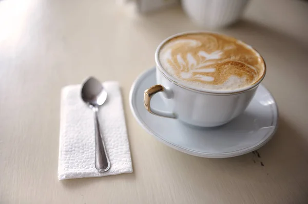 Eine Tasse Kaffee und ein Löffel auf einem Vintage-Tisch — Stockfoto