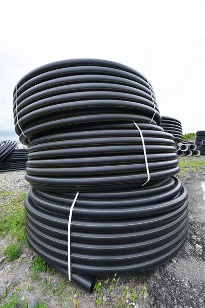 Nuevos tubos de plástico negro para el suministro de agua al aire libre — Foto de Stock