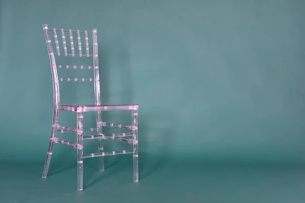 Διαφανής πλαστική καρέκλα σε πράσινο φόντο σε φωτογραφικό στούντιο — Φωτογραφία Αρχείου