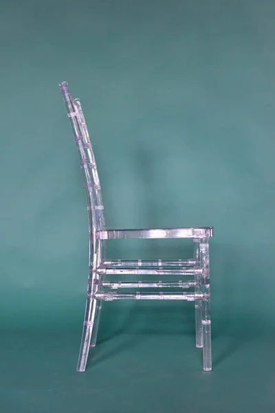 Bir fotoğraf stüdyosunun yeşil arka planında şeffaf plastik sandalye — Stok fotoğraf