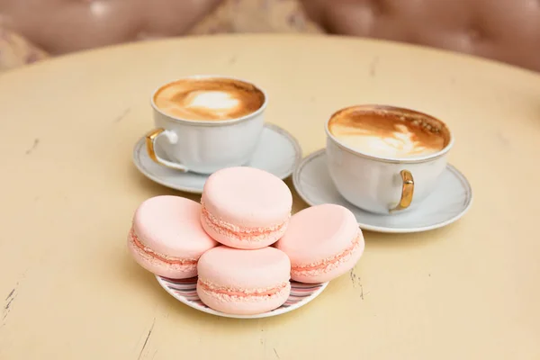 Macaroons and two cups of coffee on a vintage table — Stock Photo, Image