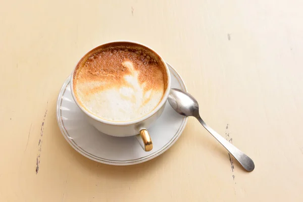 Eine Tasse Kaffee und ein Löffel auf einem Vintage-Tisch — Stockfoto