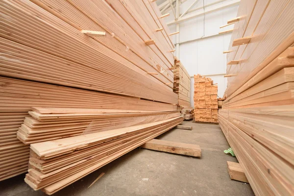 Muchos tablones de madera plegados en un almacén con un bosque — Foto de Stock