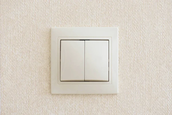 Double light switch in beige color, built into the wall