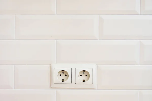 Dos tomas de corriente. Dos enchufes eléctricos de color beige en una pared beige similar a un ladrillo — Foto de Stock