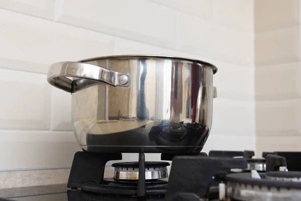 Piękny błyszczący rondel stoi na kuchence gazowej w kuchni — Zdjęcie stockowe