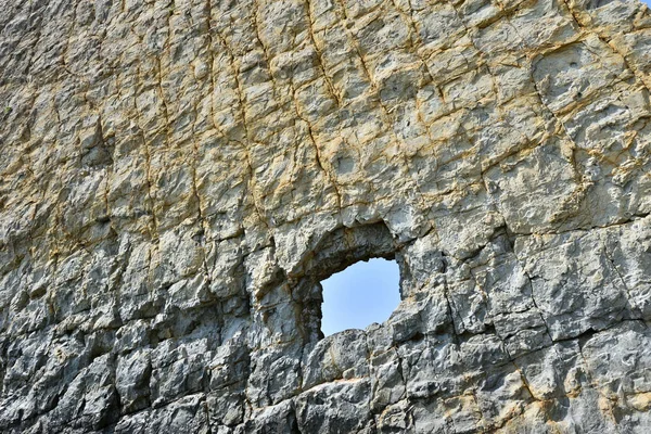 Schöner und ungewöhnlicher Felsen mit einem Loch. flach und senkrecht. felsig — Stockfoto