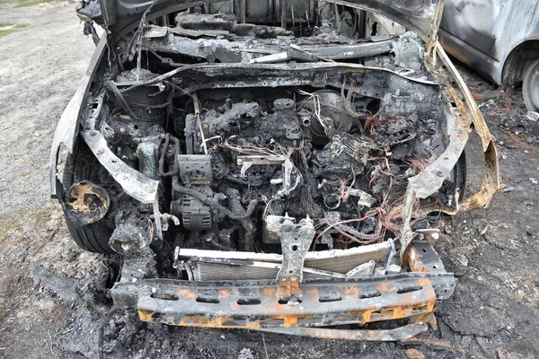El coche después del incendio. Un coche quemado con una capucha abierta. El motor se quemó. Incendios — Foto de Stock