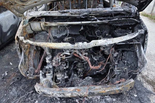 El coche después del incendio. Un coche quemado con una capucha abierta. El motor se quemó. Incendios — Foto de Stock