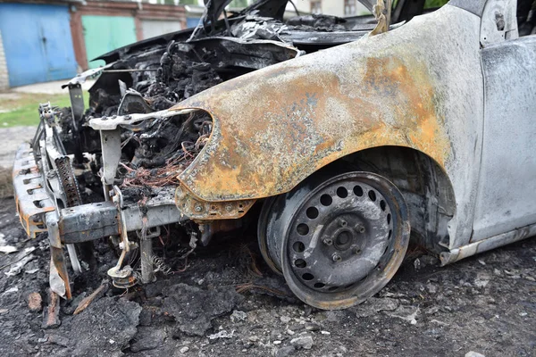 El alerón delantero del coche y la rueda sin neumático después del incendio. Coche quemado — Foto de Stock