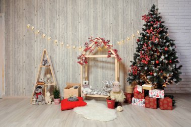 Çocuklar için yeni yıl ya da noel fotoğrafı. Ahşap bir evi, oyuncakları, Noel ağacı ve sıcak bir ışığı olan çocukların fotoğraf bölgesi.