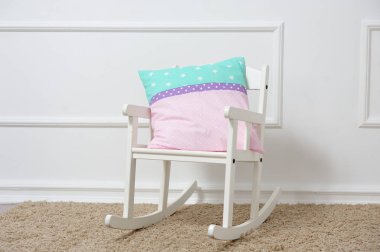 Yastık, çocuk odasındaki sallanan sandalyede duruyor.