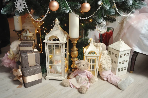 Nyårsinredning i beige under julgranen, presenter, ljus, hus och ljus — Stockfoto
