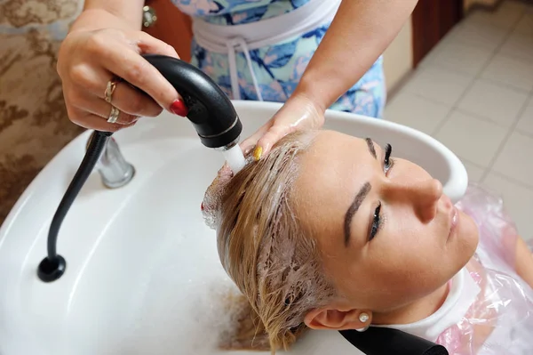 Nach dem Färben der Haare wäscht der Friseur die Haare des Mädchens — Stockfoto