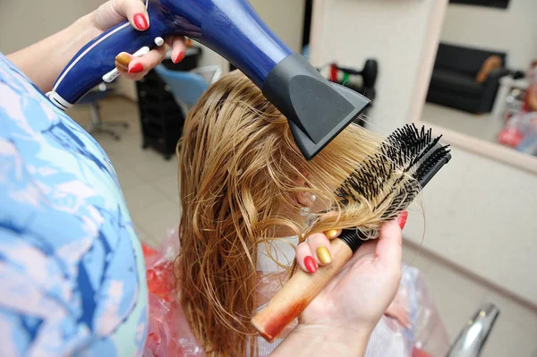 Der Friseur trocknet das nasse Haar nach dem Malen. blond — Stockfoto