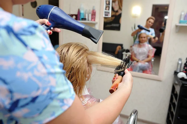 La peluquería seca el cabello mojado después de pintar. Rubia — Foto de Stock