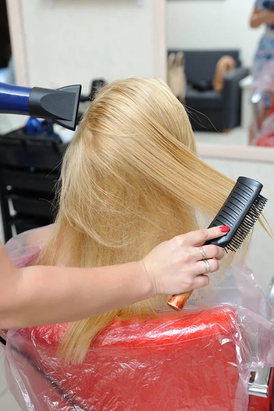 La peluquería seca el cabello mojado después de pintar. Rubia — Foto de Stock