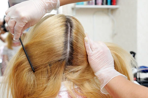 De kapper laat zien hoe het geverfde haar is gegroeid en kan zien th — Stockfoto