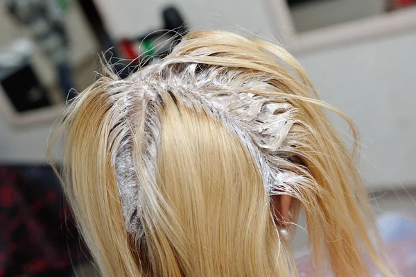 Uma menina loira foi manchada com tinta em seu cabelo em um salão de beleza — Fotografia de Stock