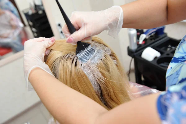 Der Friseur verwendet einen Pinsel, um den Farbstoff auf die Haare aufzutragen, für d — Stockfoto