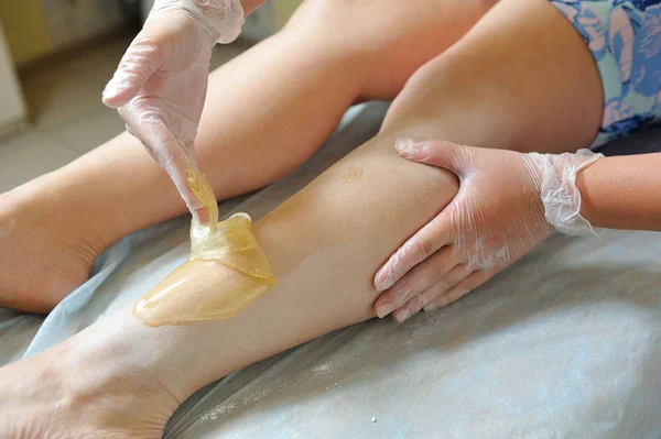 Remover pêlos desnecessários nas pernas. Procedimento de açúcar em a b — Fotografia de Stock