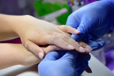 Manikürcü kızın tırnaklarını gıcırdattı ve şimdi onların tırnaklarını karşılaştırıyor.