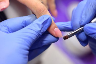 Tırnaklarına fırça sürmüş bir manikürcü. Özel bir jel.