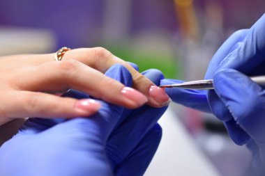 Tırnaklarına fırça sürmüş bir manikürcü. Özel bir jel.