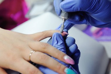 Manikürcüdeki eski jel tırnakları tırnak öğütücüsüyle onar. Şey... 