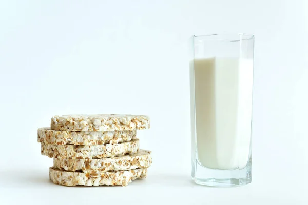 Egy pohár tej és ropogós kenyér reggelire fehér alapon — Stock Fotó