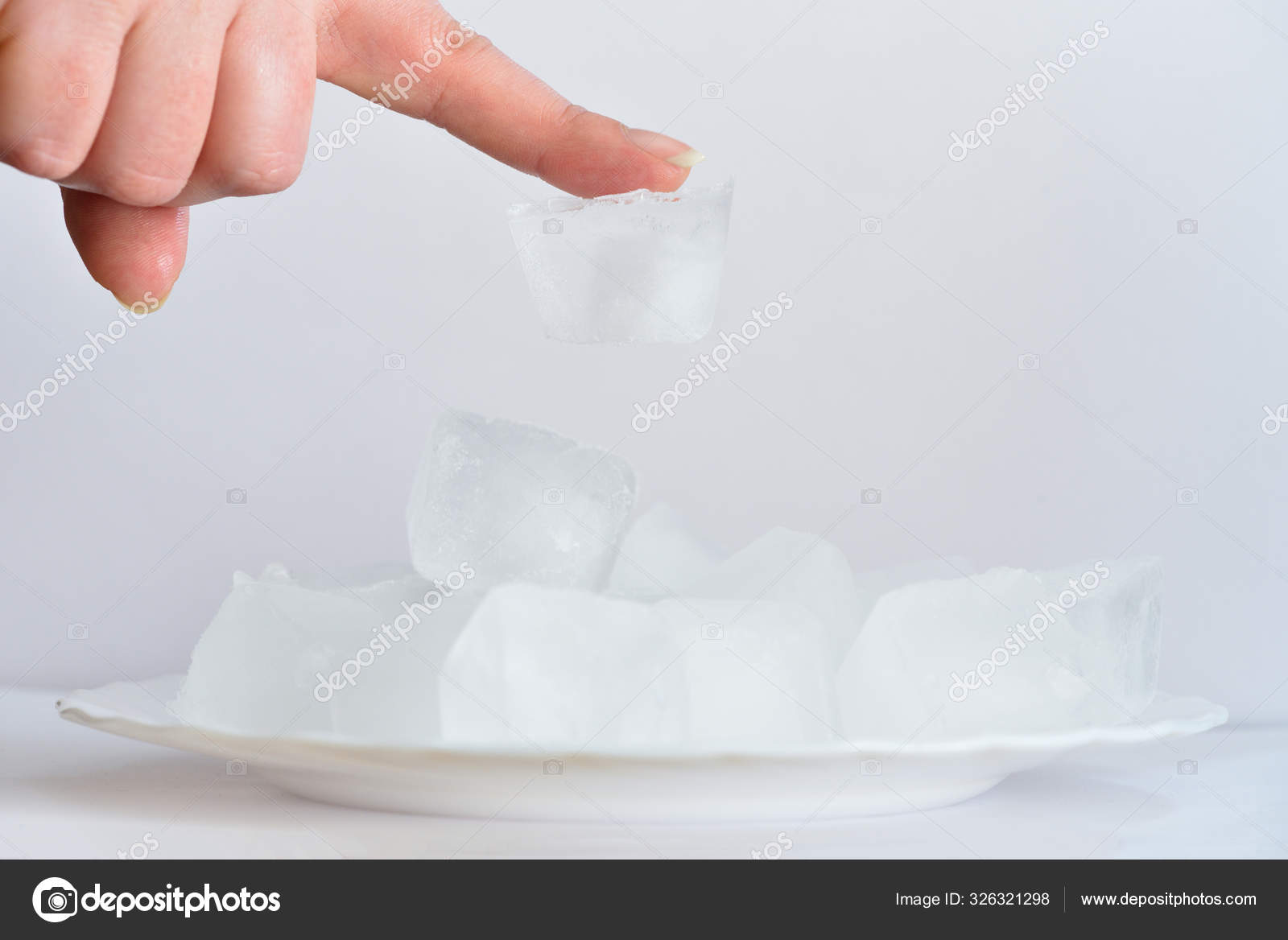 Cold ice stuck to the finger on the girl's hand. Ice stuck to the skin