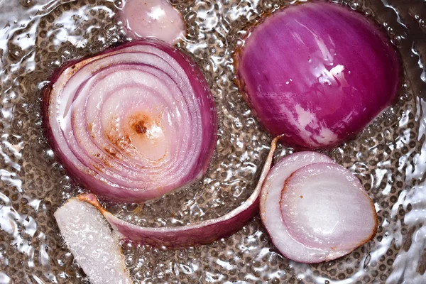 Uma bela cebola fresca metade frita-se em uma panela de ato de fritar com o óleo. Cebolas fritas. Close-up — Fotografia de Stock