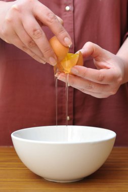 Kadın elleri mutfakta bir kase üzerinde yumurta beyazı sarısı ayrı