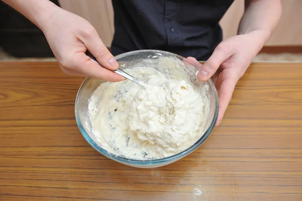 집에서 만든 피자를 만들기 위해 반죽을 준비하고, 이스트를 손으로 반죽에 넣는다 — 스톡 사진