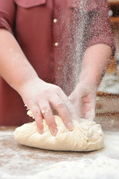 Kobiece dłonie ugniatają ciasto w kuchni na stole. Zbliżenie — Zdjęcie stockowe