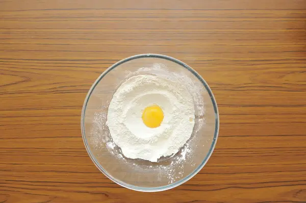 Luminoso e bello tuorlo d'uovo in farina di frumento in una ciotola trasparente di vetro — Foto Stock