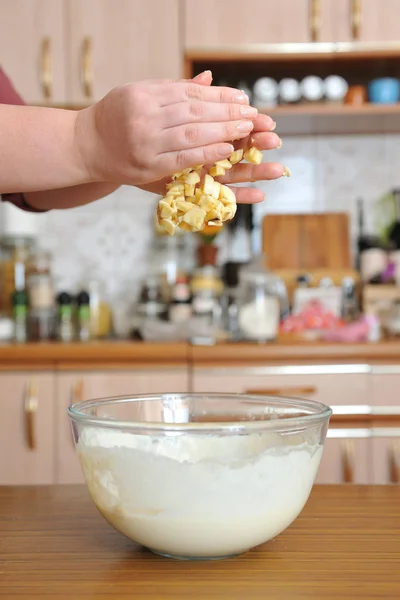 Нарезанные бананы падают с женских рук в миску для выпечки — стоковое фото