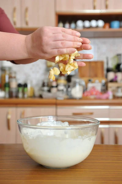 A szeletelt banán a női kézből sütőtálba hullik. — Stock Fotó