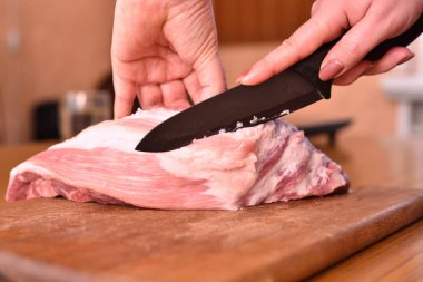 Kadınlar çiğ etle yağ keser. Kaburgalardaki domuz etinden çok fazla yağ kes. Etteki istenmeyen yağı çıkarmak için.