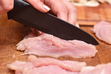 Çiğ hindi eti. Akşam yemeği için hindi eti hazırlıyorum. Bıçak hindi etini keser. Yakın plan.