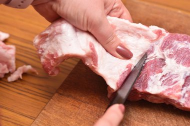 Kadınlar çiğ etle yağ keser. Kaburgalardaki domuz etinden çok fazla yağ kes. Etteki istenmeyen yağı çıkarmak için.